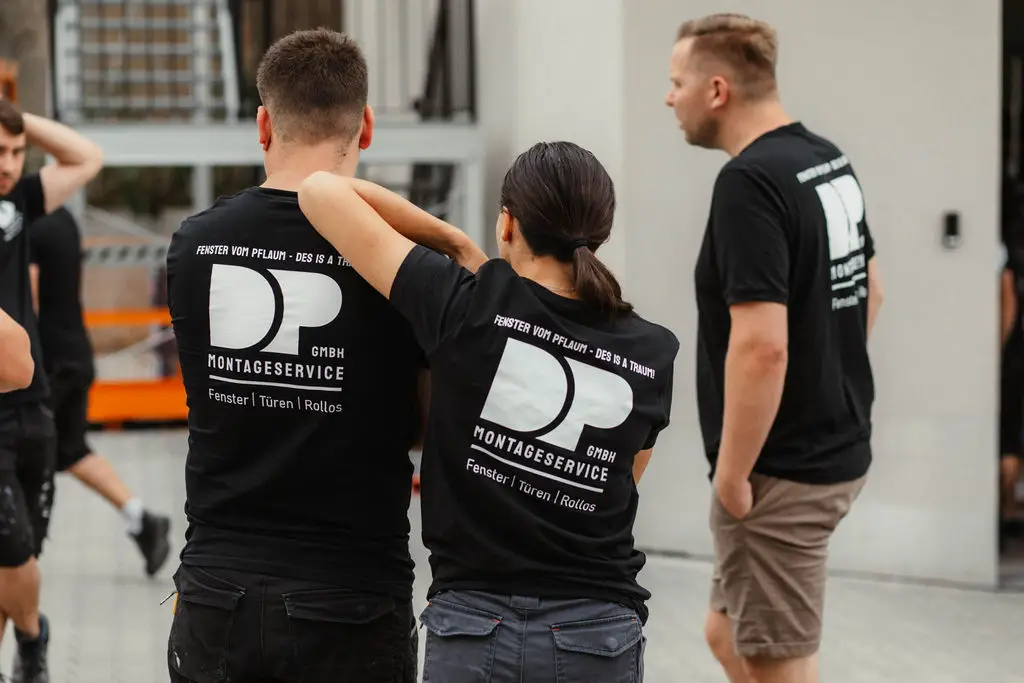 Eine Mitarbeiterin von DP Montageservice stützt sich bei einer Teambesprechung auf den Kollegen