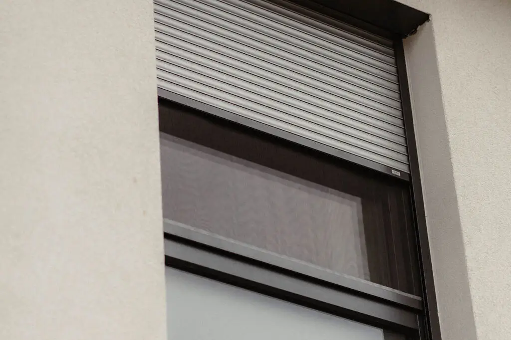 Ansicht eines Fensters mit halb geöffnetem Fensterrollo