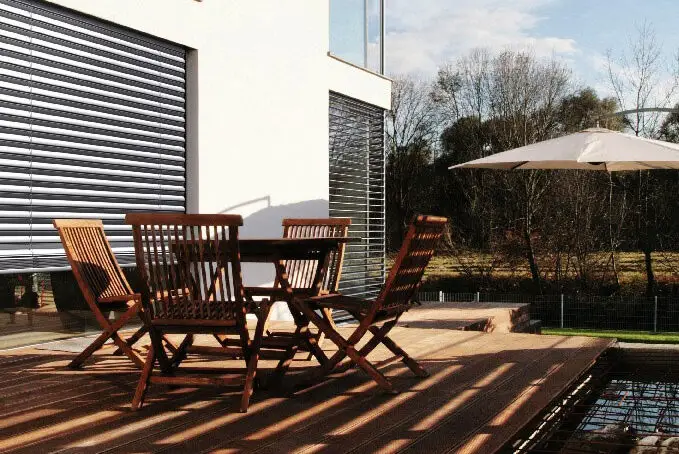 Sonnenschutz Terrasse: Holzterrasse mit Jalousien an der Fenterfront